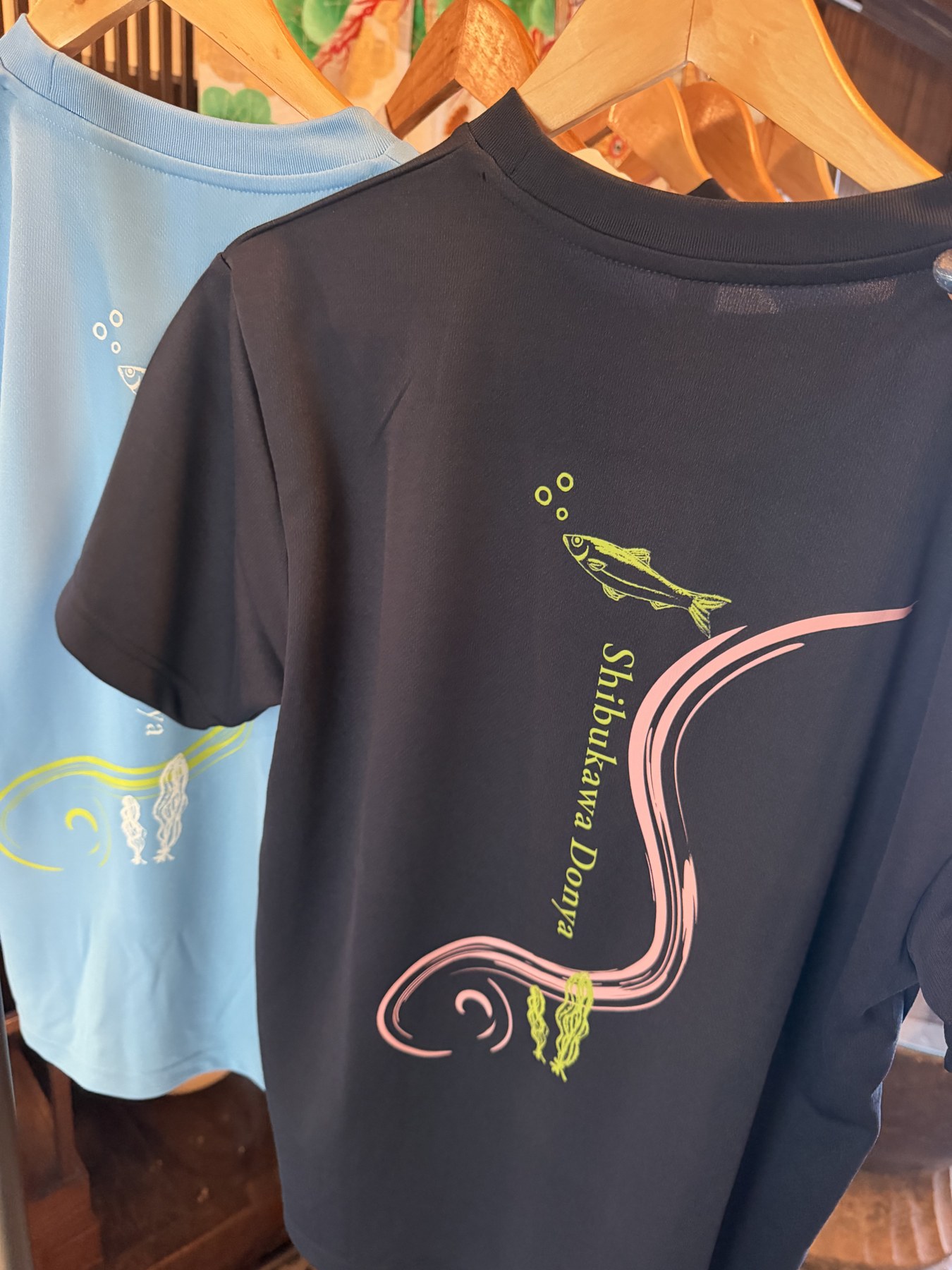 ニシンと流れる曲線をあしらったネイビーのTシャツ